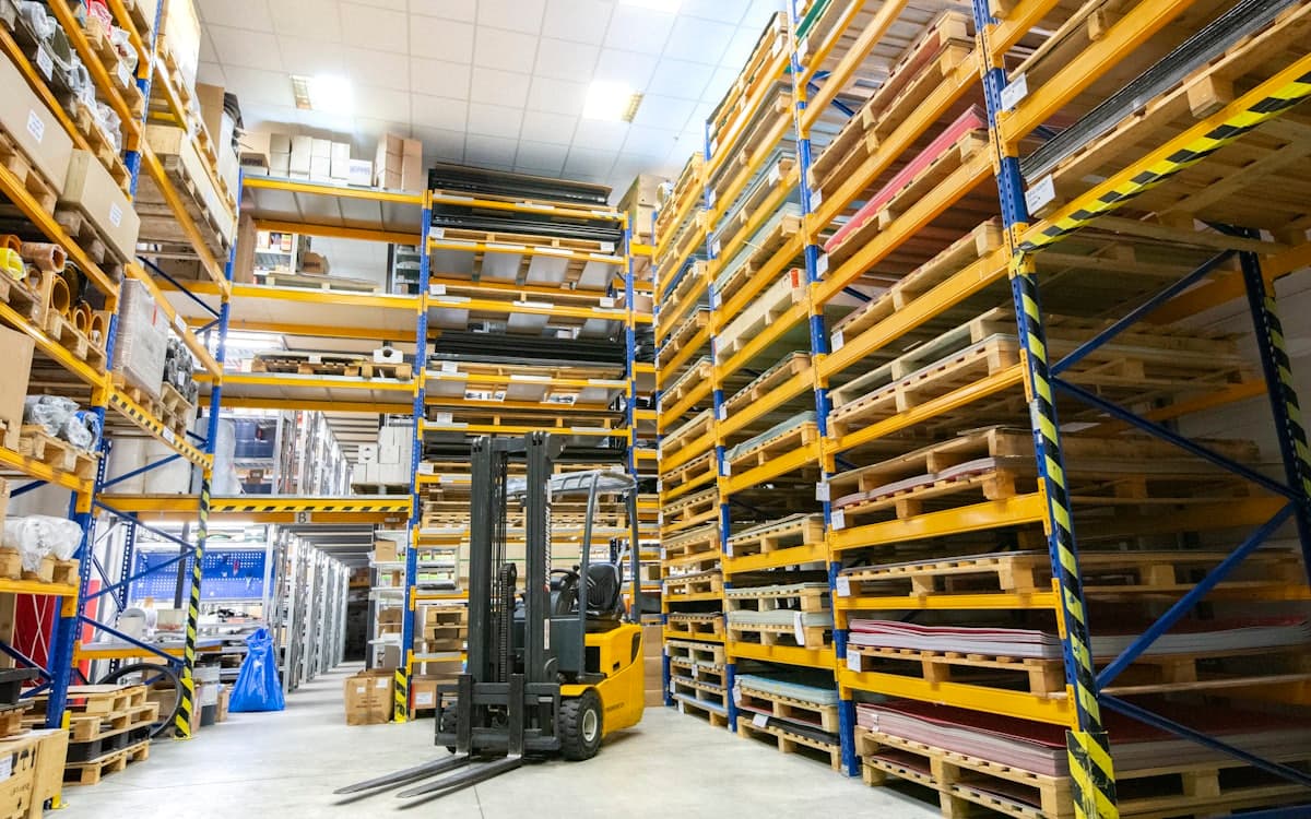 Warehouse aisle stacked with wooden pallets and racking ready for clearance