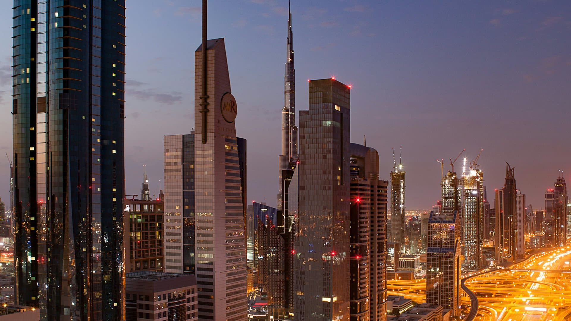 Dubai skyline and Sheikh Zayed Road lit at dusk